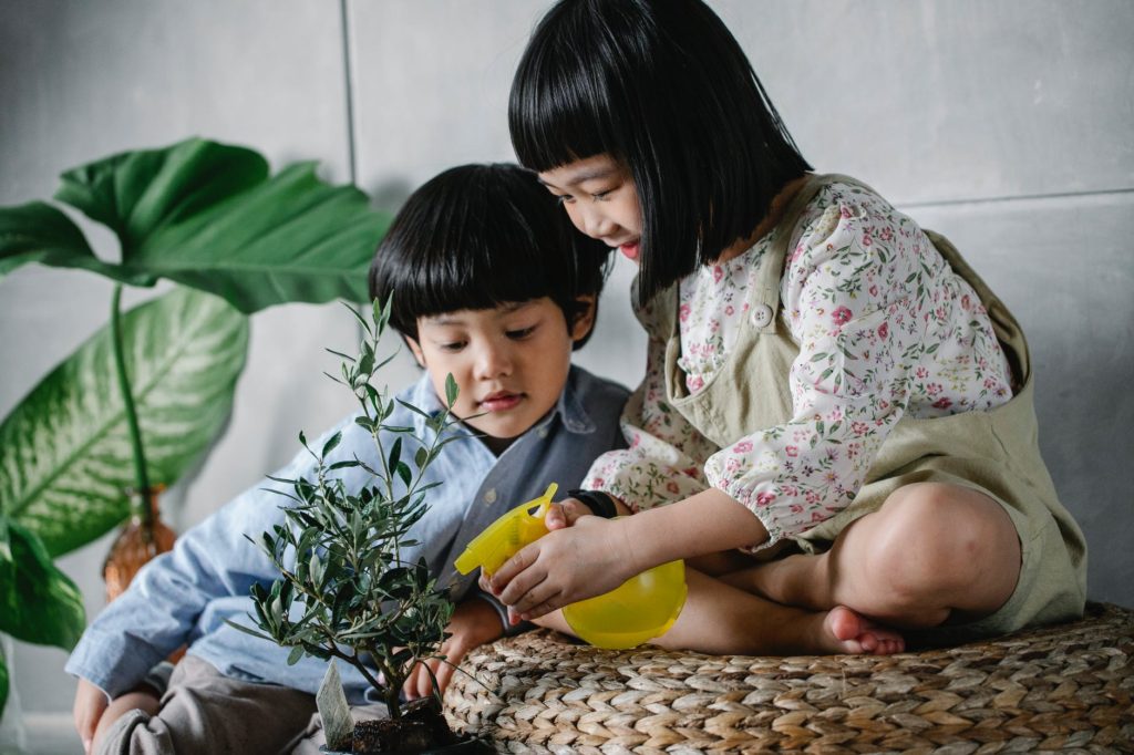 Cuide da sua saúde mental cultivando plantas! little ethnic children spraying lush plants